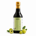 Bottle of Dhatryarishtam with green fruits on a white background